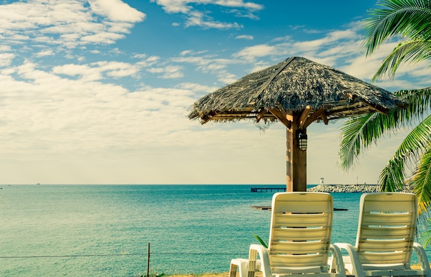 Foto tropische strandlandschaft mit strandstühlen und sonnenschirm