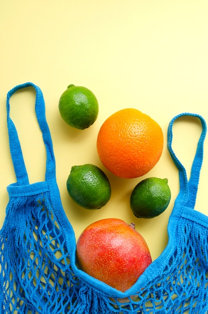 Foto tropische tasche mit mango, orange und limetten