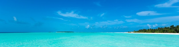 Tropischer Strand auf den Malediven mit blauer Lagune