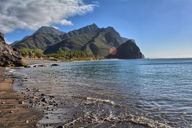 Tropischer Strand mit schwarzem Sand