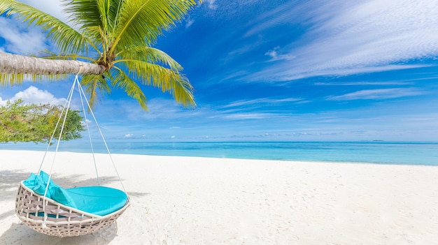 Tropischer Strandhintergrund als Sommerlandschaft mit Strandschaukel oder Hängematte auf Palme. Insel der Freiheit