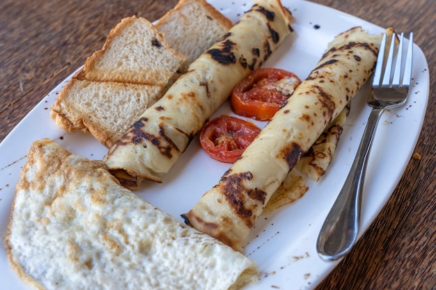 Tropisches Frühstück mit Rührei und eingewickelten Bananenpfannkuchen im Hotelrestaurant, Insel Sansibar, Tansania, Afrika, Nahaufnahme