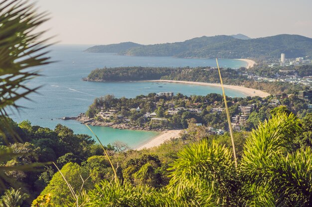 Tropisches Strandlandschaftspanorama. Wunderschönes türkisfarbenes Meer mit Booten und sandiger Küste von einem hohen Aussichtspunkt aus. Strände von Kata und Karon, Phuket, Thailand.