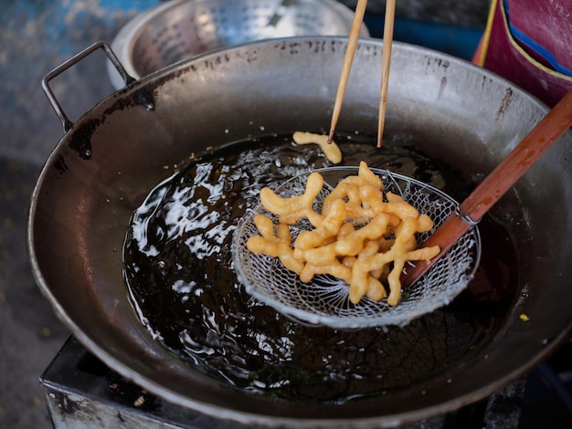 Troquelado de donut chino frito en un gran cárter de aceite