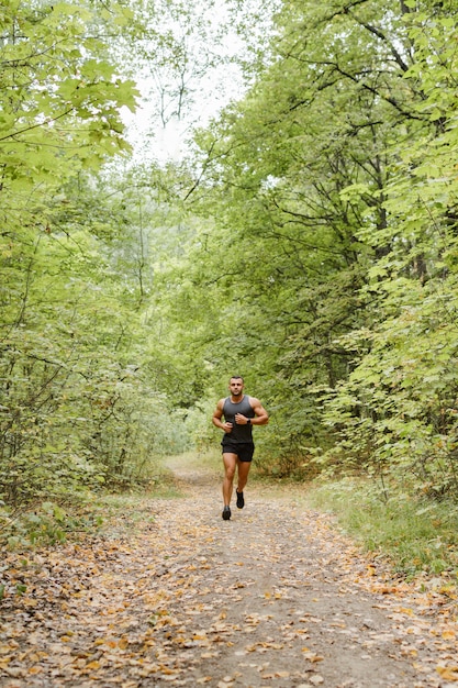 Trotar en el bosque. Atleta corriendo por el bosque.