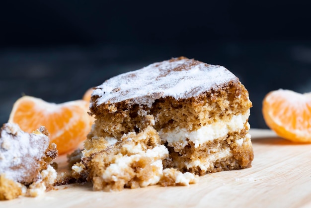 Un trozo de bizcocho de miel con crema de vainilla y mandarinas cítricas