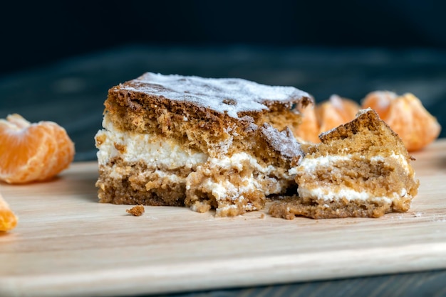 Un trozo de bizcocho de miel con crema de vainilla y mandarinas cítricas