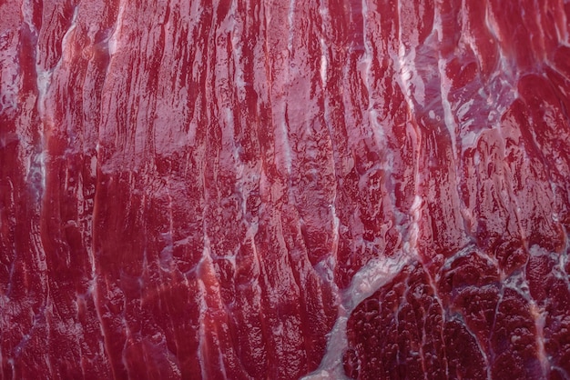 Un trozo de carne cruda fresca con especias saladas y hierbas en una tabla de cortar de madera