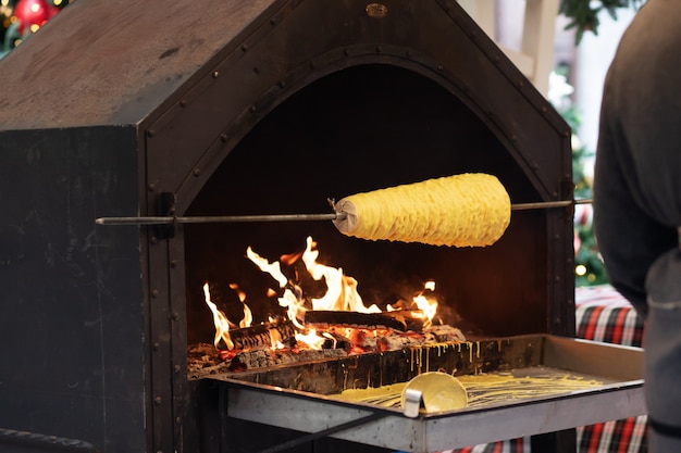 Un trozo de carne se fríe al fuego en la calle