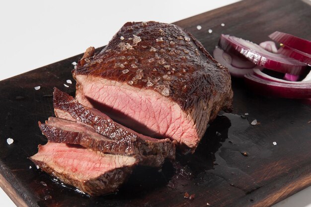 Trozo de carne frita cortada en una tira de madera