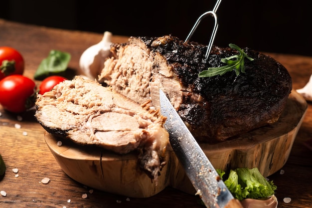 Trozo de carne picada al horno con verduras crudas sobre un fondo de madera