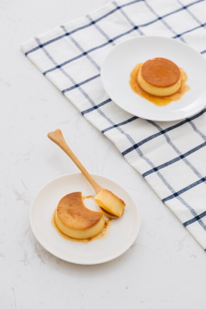 Un trozo de crema de caramelo cremoso dulce en cuchara y plato