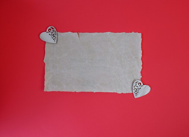 Un trozo de papel roto sobre un fondo rojo. Carta de amor