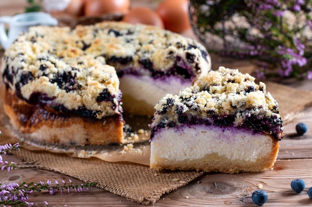 Trozo de pastel de arándanos casero con bayas en la mesa de madera de cerca