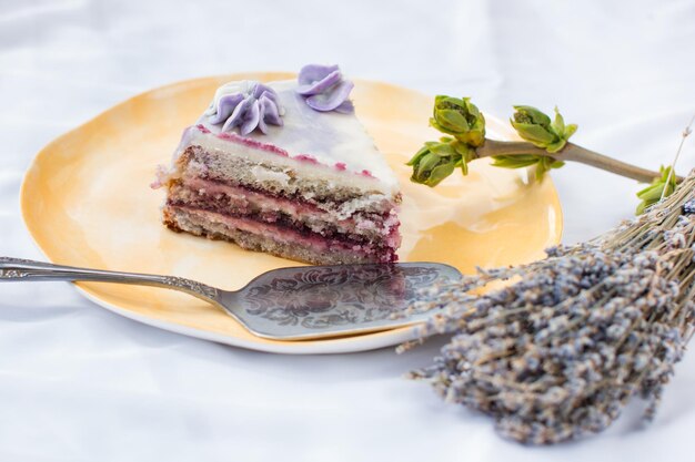 Un trozo de pastel en un plato Pastel de lavanda sobre un fondo blanco.