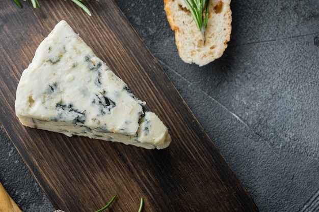 Trozo de queso gorgonzola, sobre fondo gris, plano con espacio para copiar texto