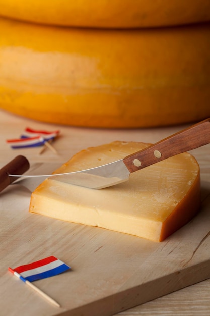 Trozo de queso Gouda maduro holandés en una tabla de cortar de cerca