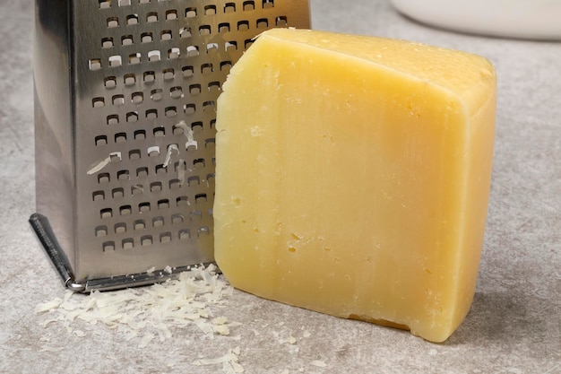 Un trozo de queso Italion Pecorino maduro y un rallado