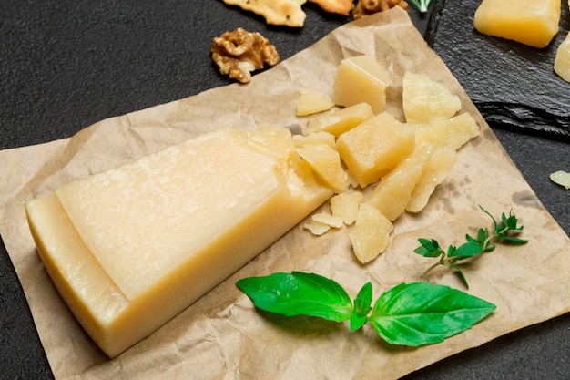 Trozo de queso pasmesano italiano en muro de hormigón