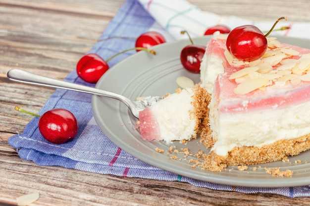 Foto trozo roto de tarta de queso en una cucharadita en un primer plano de la placa