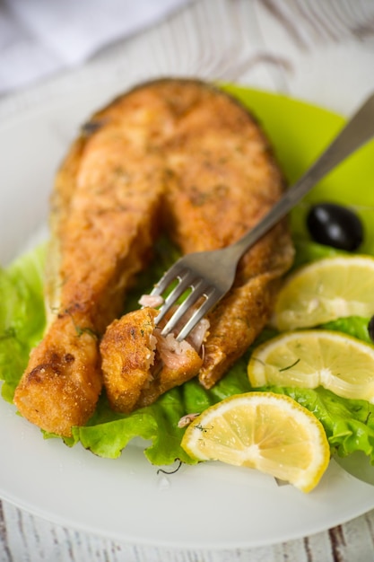 Foto trozo de salmón frito en un plato con limón