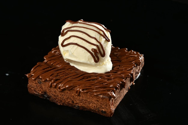 Un trozo de tarta de chocolate con una bola de helado encima.