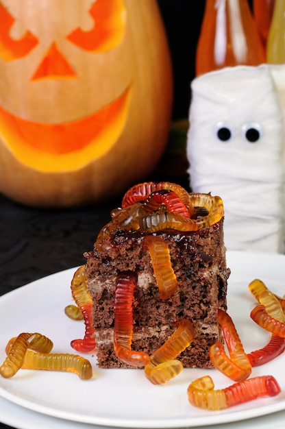 Trozo de tarta de chocolate con gusanos de gelatina