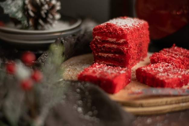 Trozo de tarta de fresa y té de frutos rojos, con adornos de invierno