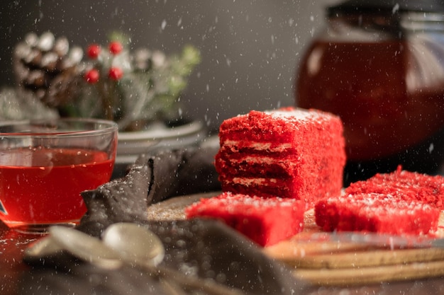 Trozo de tarta de fresa y té de frutos rojos, con adornos de invierno