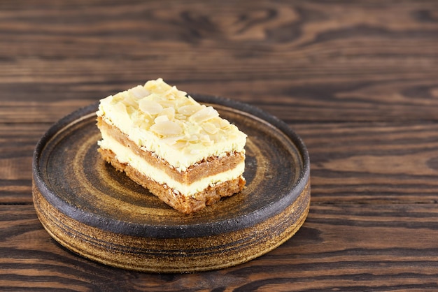 Un trozo de tarta de limón con almendras sobre una mesa de madera. Sin azúcar, gluten ni lactosa y vegano.