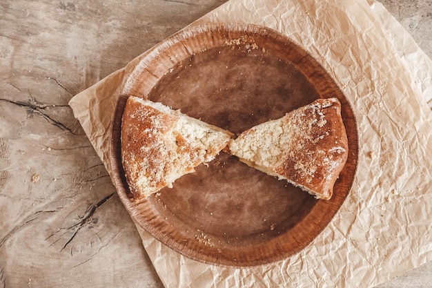 Trozo de tarta de manzana casera en un plato de papel sobre un fondo de madera