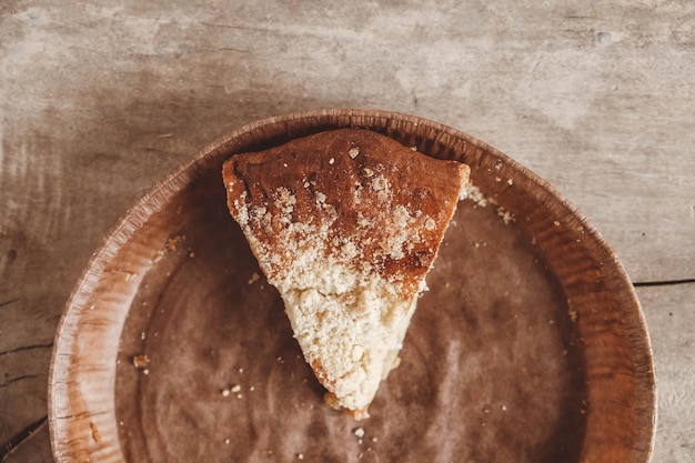 Trozo de tarta de manzana casera en un plato de papel sobre un fondo de madera