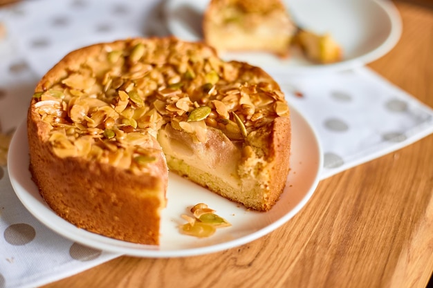 Trozo de tarta de manzana o pera con nueces de caramelo en la vista superior del espacio de copia de la mesa de madera