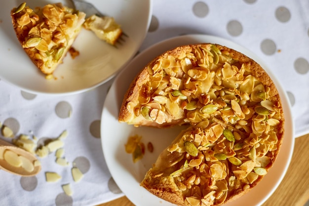 Trozo de tarta de manzana o pera con nueces de caramelo en la vista superior del espacio de copia de la mesa de madera