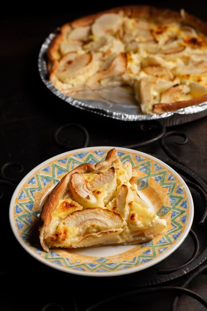 Un trozo de tarta de manzana en un plato sobre un fondo oscuro Rodajas horneadas en masa de manzana Charlotte