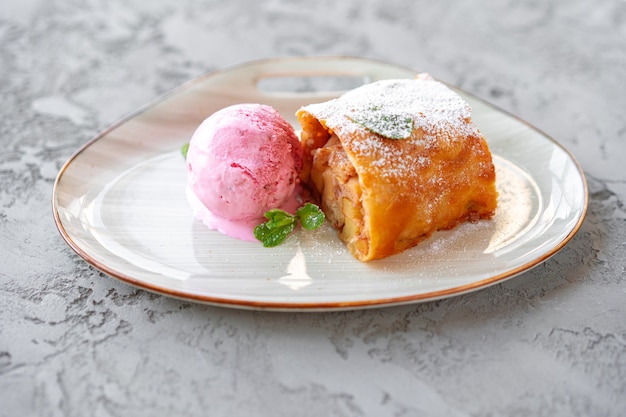 Trozo de tarta de manzana servido con helado