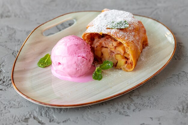 Trozo de tarta de manzana servido con helado