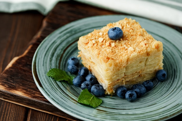 Trozo de tarta Napoleón en placa verde