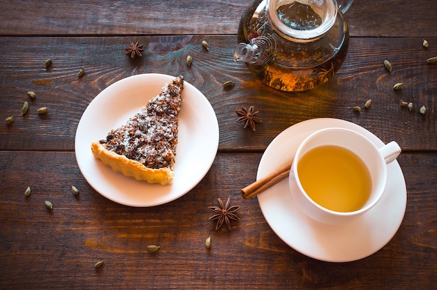 Trozo de tarta de nueces con té de hierbas en la mesa de madera