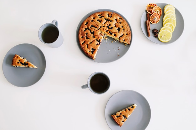 Trozo de tarta en un plato con una taza de té en el cuadro blanco