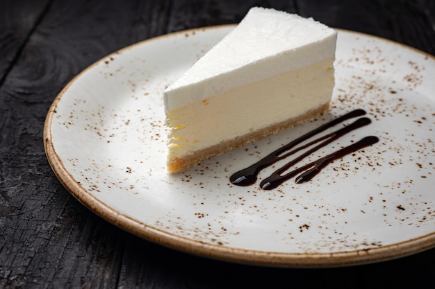 trozo de tarta de queso con crema y chocolate en un plato blanco