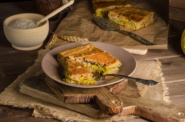 Trozo de tarta en rodajas con repollo sobre una superficie de madera en un estilo rústico