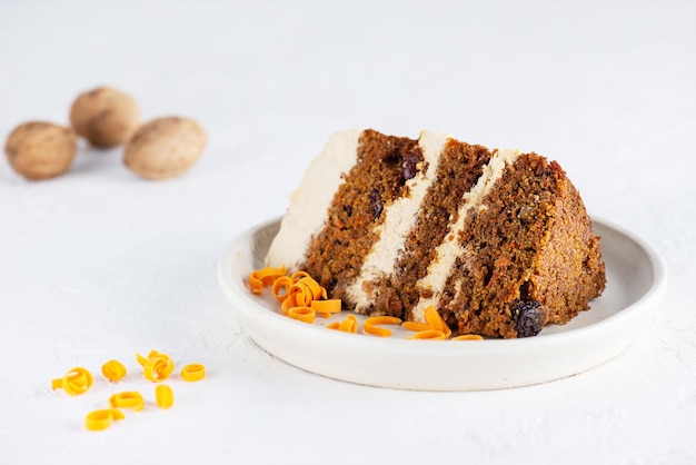 Un trozo de tarta de zanahoria con nueces de crema de coco en un plato