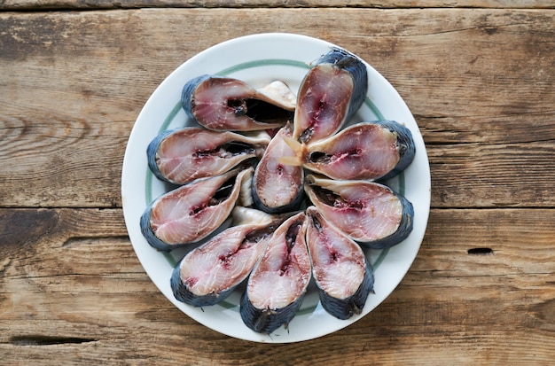 Trozos de arenque salado en un plato blanco