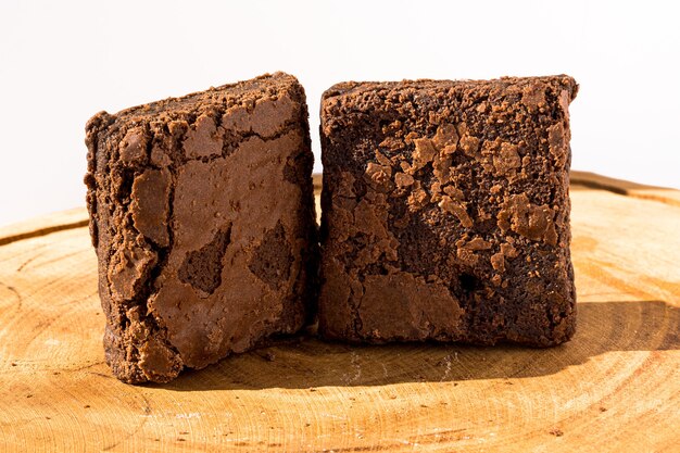Trozos de brownie fresco sobre fondo de madera. Pastel de chocolate delicioso. Primer plano macro. Enfoque selectivo.