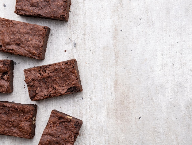 Trozos de brownies sobre una mesa de madera blanca con espacio para copiar