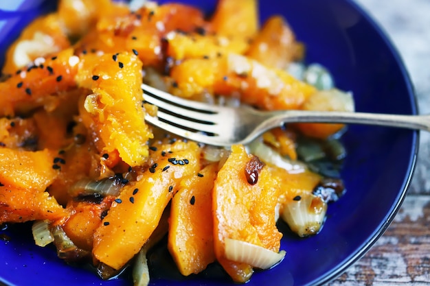 Trozos de calabaza al horno con cebolla en una placa azul Receta de calabaza Comida de otoño