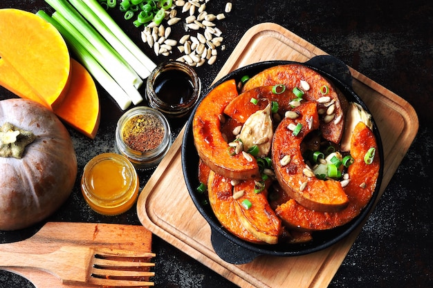 Trozos de calabaza al horno en una sartén pequeña con verduras y semillas. Calabaza horneada. Almuerzo vegano con calabaza al horno picante. Útil merienda de otoño. Almuerzo de Halloween