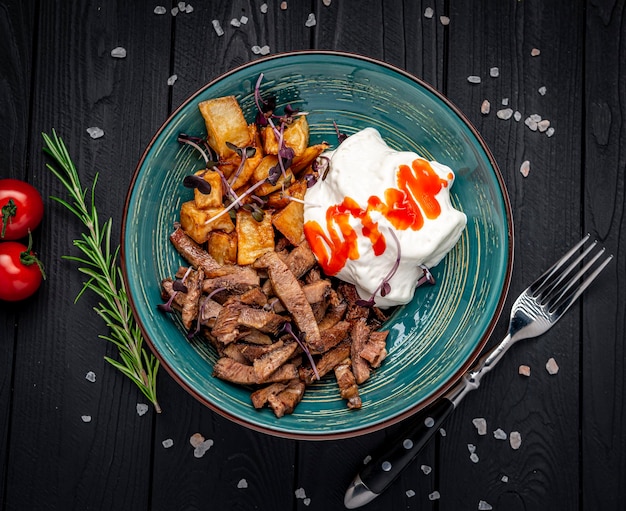 Trozos de carne frita con salsa cremosa y berenjena frita