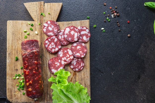 Trozos de carne de salchicha manteca de cerdo tocino carne de res o cerdo ahumado o bocadillo de comida curada en seco en el espacio de copia de mesa